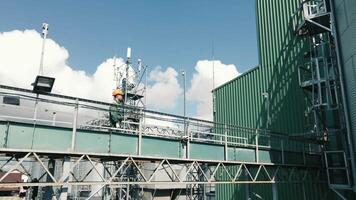 The production engineer goes over the metal structures and inspects the plant. An employee of a large enterprise walking on the territory video