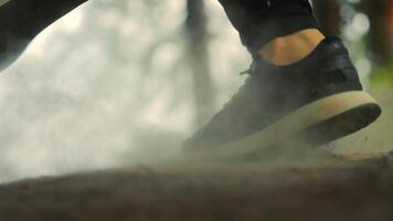 Legs of an athlete close up running on a forest trail. Dust arising from running fast. Jogging in the morning in the park close up.running man, sneakers close up leg running on forest path video