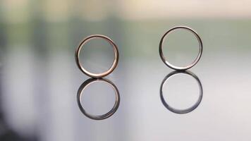 Boda anillos un del hombre Boda anillo rollos a través de el vaso mesa a un mujer Boda anillo. video
