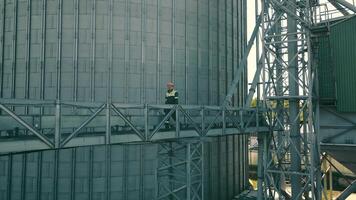 The production engineer goes over the metal structures and inspects the plant. An employee of a large enterprise walking on the territory video