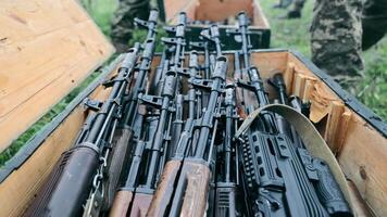 The military puts Kalashnikov assault rifles and sniper rifles in a box. Unloading of military equipment. Hand close up puts in a wooden box Kalashnikov rifle and sniper rifle. video