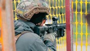 militär skjuter med en maskin pistol stänga upp. en kämpe av de amerikan trupper försiktigt syftar till på de fiende och drar de avtryckare av de maskin pistol. skott från en maskin pistol. video