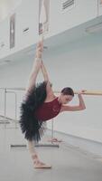 un' professionale ballerina è formazione vicino il balletto barre nel il sala. un' danza ragazza. verticale formato per il Telefono. video