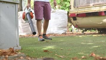 sem fio folha sopradores. portátil, sem fio, elétrico folha ventilador dentro uma jardim, seletivo foco. outono, outono jardinagem trabalho dentro uma quintal, em uma grama, grama. jardim funciona. video