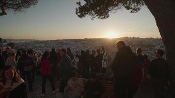 Lisbon, Portugal - April 9, 2024 - People enjoy the sunset while gazing at the city of Lisbon from atop Miradouro da Graca video