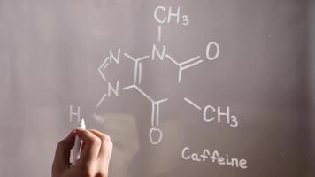 kemisk strukturera, formel av koffein på glas i de labb närbild. föreläsning på kemi. en forskare kemist skrivningar i vit video