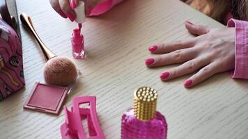 uma mulher faz uma manicure, tintas dela unhas Rosa dentro a estilo do Barbie, fechar-se. senhora noiva é obtendo pronto para uma solteira festa video