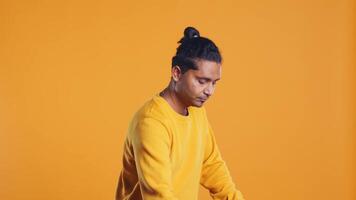 Portrait of man holding thermal backpack, crossing arms, ready to fulfill orders, studio backdrop. Calm food delivery service worker prepared to do delivery to customers, camera B video