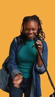 Vertical Portrait of african american motivational speaker talking in microphone, addressing audience, isolated over studio background. Expressive lecturer using mic, inspiring motivation, camera B video