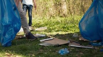 Mannschaft von Freiwillige Sammeln Müll zu Fix Verschmutzung Problem innerhalb das Lebensraum, schützen das natürlich Umfeld. Aktivisten tun freiwillig Arbeit zu sauber das Wald von Müll. Kamera b. video