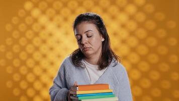 agotado mujer bostezando, participación pesado apilar de libros necesario para colegio examen, estudio antecedentes. estudiante anhelo para dormir, cansado de aprendizaje desde académico libros de texto, cámara si video