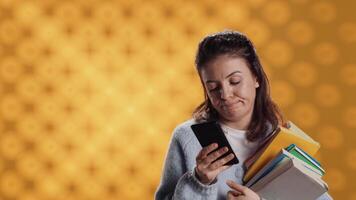 trastornado mujer participación apilar de libro, preparando para colegio examen utilizando teléfono, estudio antecedentes. estudiante con pila de libros de texto haciendo pucheros mientras investigando para Universidad deberes utilizando teléfono inteligente, cámara un video