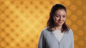 Cheerful woman happily doing salutation hand gesture, feeling optimistic. Portrait of joyous caucasian person raising arm to greet someone, gesturing, isolated over studio background, camera A video