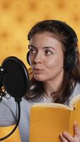 Vertical Voice actor looking to producer off camera to know when to start narrating book, producing audiobook. Narrator doing counting on fingers gesturing before starting digital recording of novel, camera A video