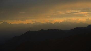 tibetano montanhas às pôr do sol, silhuetas do nuvens dentro a céu. video