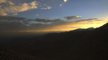tibetano montanhas às pôr do sol, silhuetas do nuvens dentro a céu. video