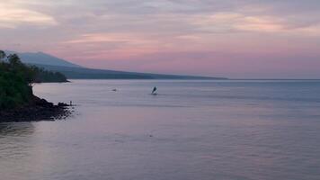 Fisherman's boat at sunset volcano in the background video