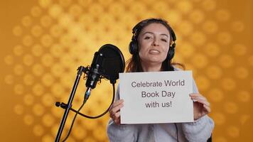 glimlachen vrouw filmen promotionele voor wereld boek dag, geïsoleerd over- studio achtergrond. influencer bevorderen lezing, winnen bewustzijn voor Internationale globaal evenement, camera b video