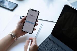 CHIANG MAI, THAILAND - NOV 07, 2020 . Woman hand holding iphone with login screen of instagram application. Instagram is largest and most popular photograph social networking. photo