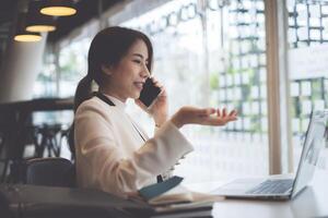 Business coffee shop owner talking with customer and telling cafe is back to open now and safe after covid-19 have vaccine. Female take the phone and make ads on laptop. photo