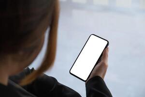 Woman using smartphone blank screen frameless modern design while work from home photo