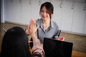 Business team giving a high fives gesture as they laugh and cheer their success. Achievement and Business Goal Success Concept. photo