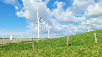 View from the side window of a moving car of a large wind farm on meadows. video