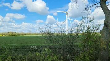 View from the side window of a moving car of a large wind farm on meadows. video