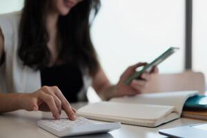 mano de mujer de negocios con bolígrafo y teléfono celular con aplicación de cuenta de ahorros bancarios, cuenta o ahorro de dinero o concepto de seguro. foto