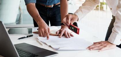 Two Architect man working with laptop and blueprints for architectural plan, engineer sketching a construction project concept. photo