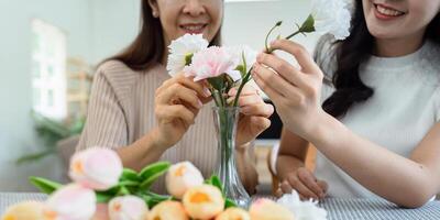 Mother and daughter arrange flower together at home on the weekend, family activities, mother and daughter do activities together on Mother's Day photo