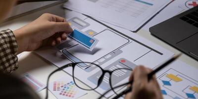 A close-up of an ux ui developer and an ui designer working on a mockup icon interface for a mobile app. photo