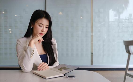 mujer de negocios pensando acerca de trabajo con cuaderno a su oficina escritorio. foto