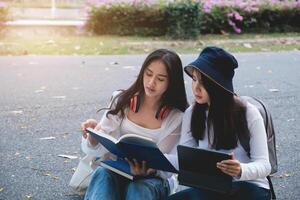 Two students are sitting in university during reading a book and communication. Study, education, university, college, graduate concept. photo