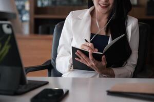 Business woman reading minute of meeting on her notebook in office. vintage effect and selective focus. photo