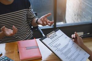 Businesswoman reading resume of man on document during an interview. photo