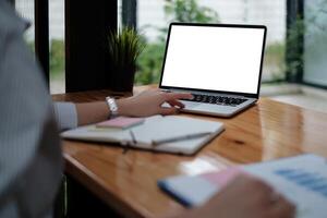 business woman sitting in office with laptop computer on desk photo