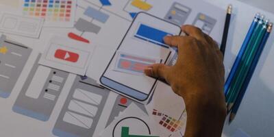 Designers drawing mobile ux app development concept. Man hold pencil with mockup ui. photo