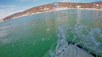 Surfer riding on surfboard on ocean wave. First-person view of surfing in ocean video