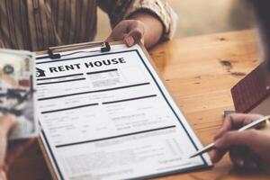 Following a deal with a broker, A Man signs a contract to rent a house. photo