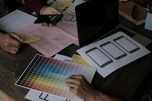 Until creating a mobile application, a developer compares color and interface wireframes photo