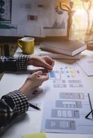 Rear view developer ux and ui designer about mobile phone app and choosing some interface to mockup phone. Creative digital development agency concept. photo