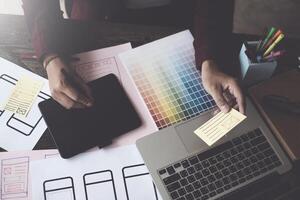 Until creating a mobile application, a developer compares color and interface wireframes photo