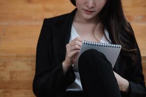 Cropped image of a businesswoman jotting down ideas on a notepad photo