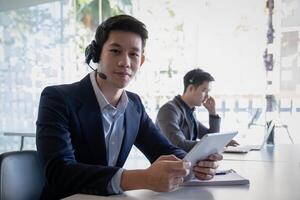 Customer support operator team with hands-free headset working in the office. photo