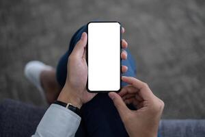 A Man hand holding smartphone device with blank screen. top view. photo