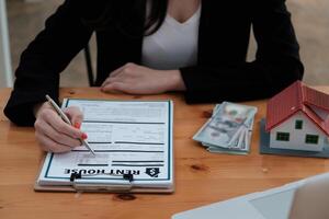 Following a deal with a broker, a woman signs a contract to rent a house photo