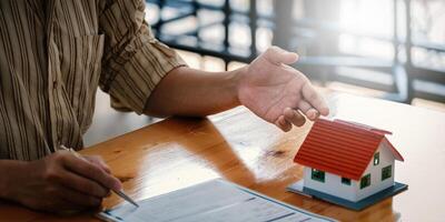 Businessman hand and contract agreement paper with customer to sign contract. Real Estate and Agreement concept photo