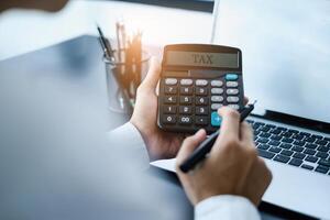 A man calculates taxes with a calculator. photo