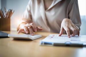 Young accountant man analyzes financial data using calculator and laptop computer to compute and summarize big data for present on conference. financial concept. photo